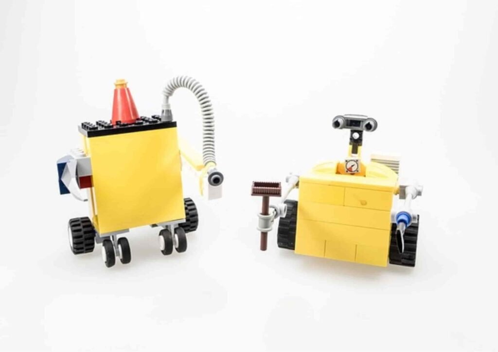 two small bots with different tools in hand with white background 