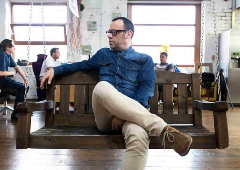 Person sitting on a wooden swing. likely to be a manager 