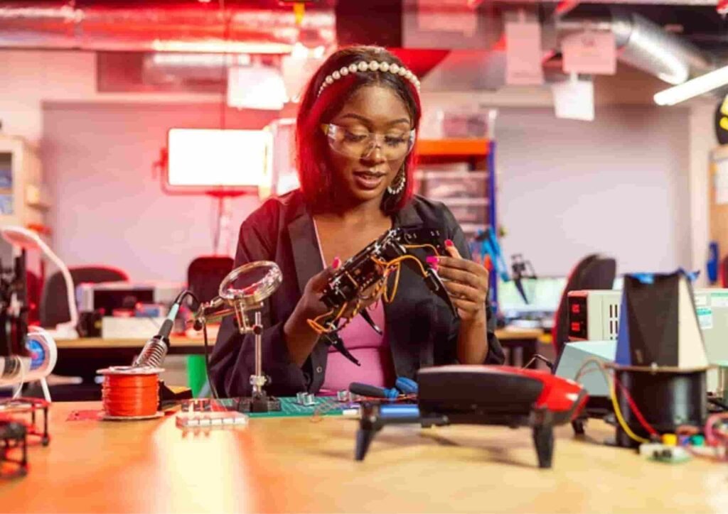 Person assembling electronic components in workshop. 