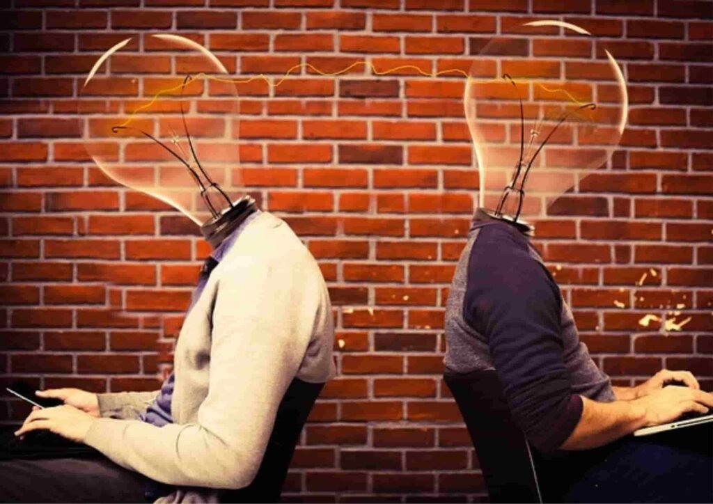 Two people with lightbulb heads. doing creative work a job that can't be replaced by Ai