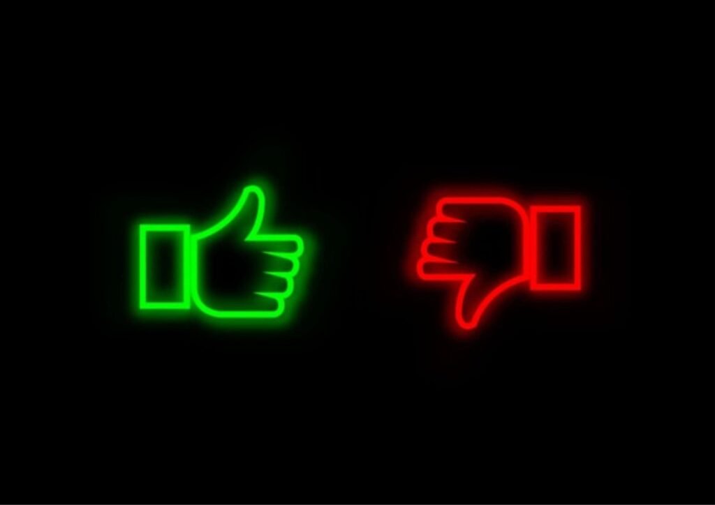 Neon green thumbs-up and red thumbs-down icons on a black background, symbolizing the pros and cons of CheatBuster AI in detecting