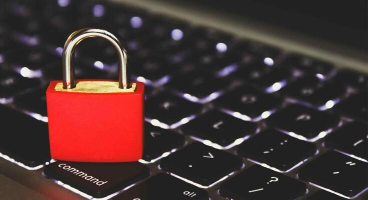 Cyber security and network support concept showing red padlock on computer keyboard